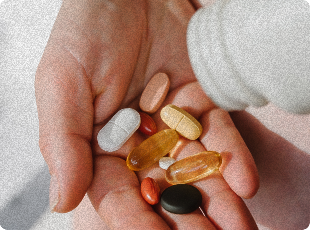 A hand holding different supplements